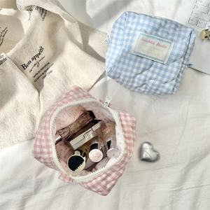 Detailed view of quilted plaid makeup bags in pink and blue showing large storage capacity
