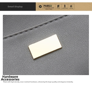 Close-up of golden rectangular metal buckle on grey lychee pattern leather tote bag