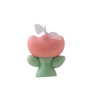 Pink tulip scented candle with green stem and white ribbon on white background