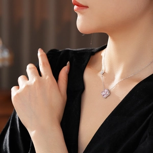 Silver four-leaf clover necklace with pink and clear zircons on model neck