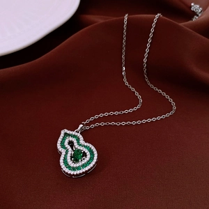 Detail of 18K gold plated gourd pendant with green emerald and white crystals
