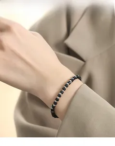 Dettaglio di un bracciale con perline di pietre sfaccettate nere e sfere argentate