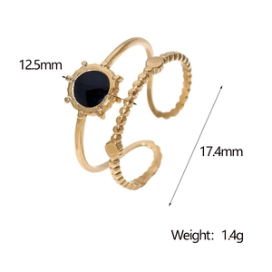 Detail view of adjustable gold ring featuring a black disc surface and beaded edges
