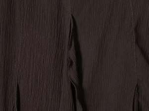 Détail des couches de volants texturés et des coutures plissées sur la jupe noire