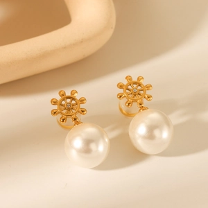 18K gold plated helm earrings with shimmering pearls and rhinestones on a warm background