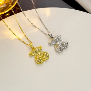 Macro view of gold and silver mechanical bear pendants with rhinestones on a white stand