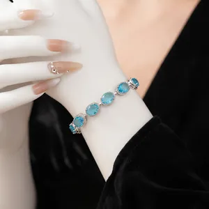 Elegant silver bracelet with oval sky blue cubic zirconia stones on female model