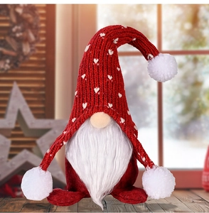 Detail eines Weihnachtsgnoms mit roter Strickmütze und weißem Plüschbart als Deko