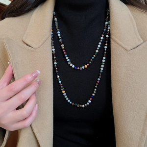 Close-up of layered bohemian necklace with colorful faceted crystal beads on model