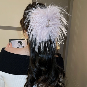 Detail of a plush feather hair claw clip in soft lavender for elegant updos for women