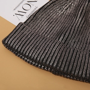 Macro detail of the silver metallic coating and ribbed texture on this knitted beanie hat