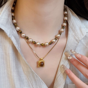 Detail of double-layer necklace with tiger eye stone pendant and coffee pearls
