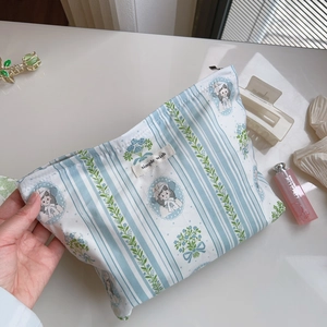 Detailed shot of a striped cotton makeup bag with floral print and simple wish label