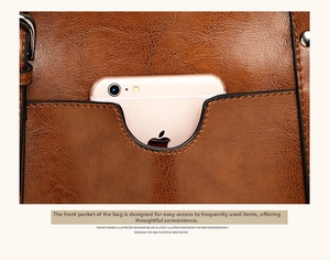 Detailed macro view of the front pocket on a brown leather tote bag with smartphone