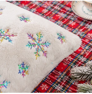 Close-up of cream plush cushion cover featuring colorful sequin snowflake embroidery