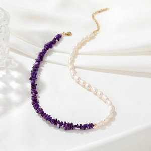 Elegant necklace with purple mineral stones and white pearls on white silk background