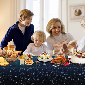 Family gathered around a navy blue starry sky tablecloth for a festive home dinner