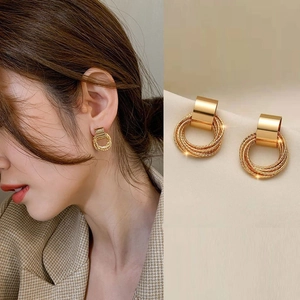 Detail of vintage gold layered hoop earrings on model and close-up textured circles