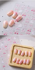Detailed view of pink bow and cherry nail art stickers on matte press-on nails