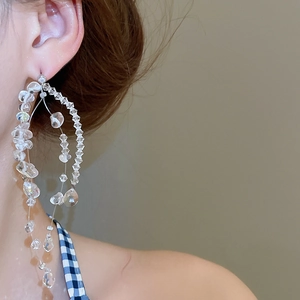 Nahaufnahme der hängenden Kristallperlen-Ohrringe am Modell für einen trendigen Look