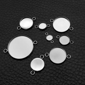Polished stainless steel round bezel pendant trays in various sizes on black leather