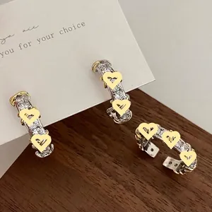 Modern geometric crisscross earrings with gold and silver tones and white zircon stones