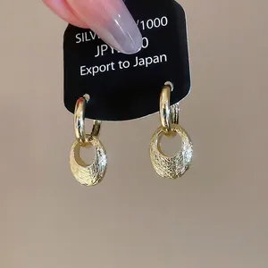 Minimalist gold oval earrings with textured brushed metal finish and round clasps