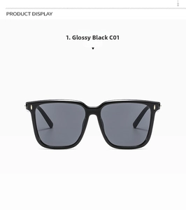 Detail view of shiny black oversized square sunglasses with metal accents and grey lenses