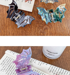 Detailed view of gothic bat-shaped acetate hair claw clips with marble textures