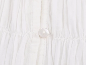 Detailed macro view of white poplin fabric texture and matching button on a shirt