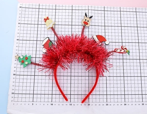 Détail d'un serre-tête de Noël avec élan et chapeau de Père Noël sur fond quadrillé gradué