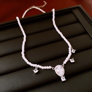 Detailed close-up of water drop zircon pendant on a luxury pearl beaded necklace