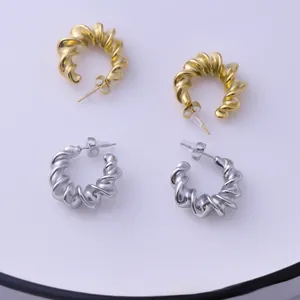 Detailed view of spiral twisted metal stud earrings in polished gold and silver finishes