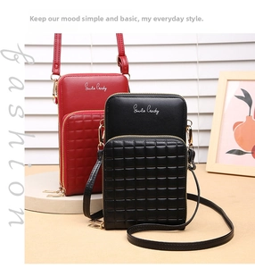 Close-up of red and black crossbody phone bags with textured grid patterns and gold zippers