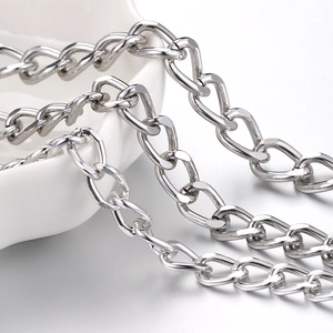 Flat silver stainless steel Cuban link chain necklace for men and women on white tray