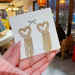 Close-up of heart-shaped tassel earrings with S925 silver needles and sparkling zircons