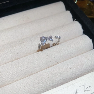 Detail of silver bow ring featuring micro-pave crystals and delicate white pearls