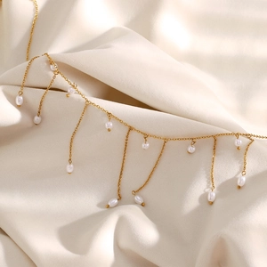 Détail du collier en acier inoxydable plaqué or 18K avec pompons en perles élégants