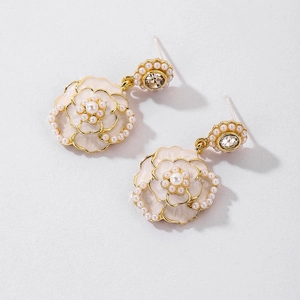 Detailed view of pearl camellia earrings with gold edges and sparkling rhinestones