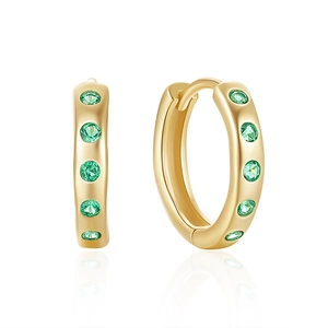 Detail of gold huggie earrings with five round green gemstones on white reflection