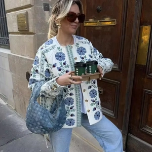 Veste matelassée blanche pour femme avec broderies florales bleues et ceinture