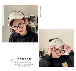 Detail of beige knitted sun visor for kids with SPORT logo and round glasses