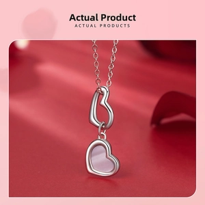 Macro shot of 925 silver necklace with double heart pendant and pink gemstone detail