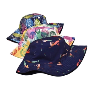 Detailed view of three reversible bucket hats with various sea animal patterns and prints