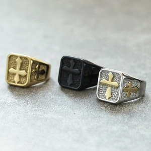 Close-up of vintage stainless steel rings with cross reliefs and stone texture finish