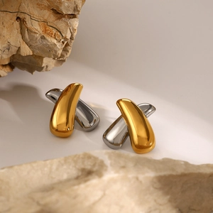 Macro view of two-tone gold and silver stainless steel earrings with streamlined cross design