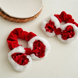 Close-up of red sequin bow hair scrunchies with white plush trim for Christmas party