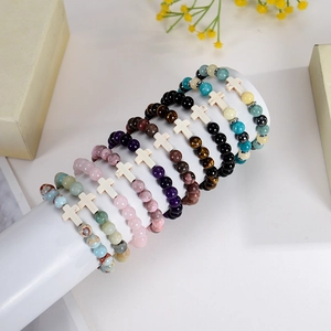 Vue détaillée de plusieurs bracelets en pierres naturelles de 8mm avec charms en croix