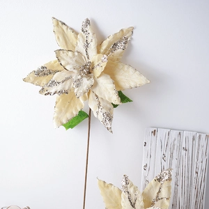 Off-white artificial poinsettia flower with silver glitter edges and green leaves
