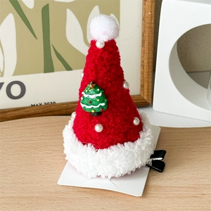 Detailed view of plush red Christmas hat hair clip with pearl and resin tree embellishment